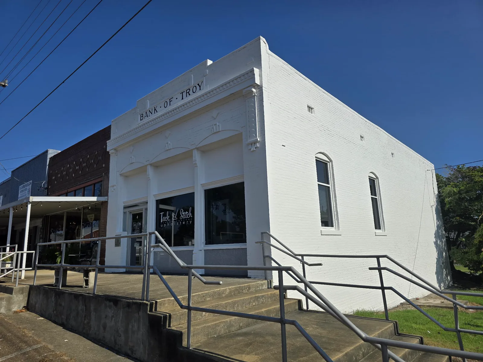A freshly painted white brick storefront in Troy, Tennessee: a historic building restored and repainted by Allen's Painting.
